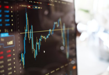 A blue and yellow graph on a stock market monitor.