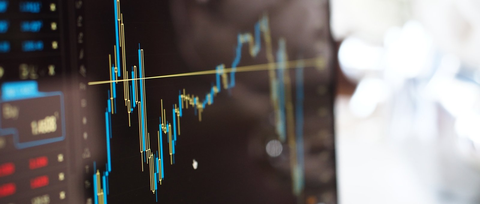 A blue and yellow graph on a stock market monitor.