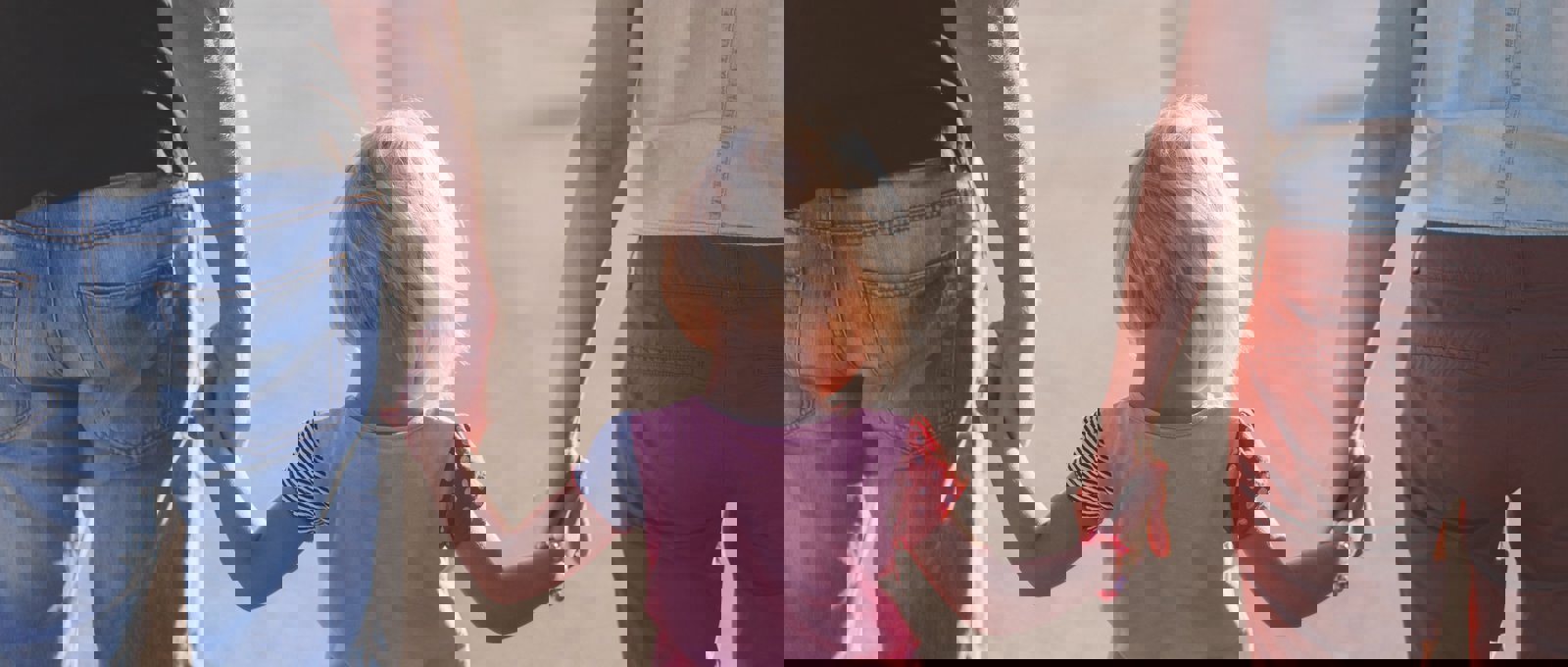 Little girl holding hands in the middle of two adults