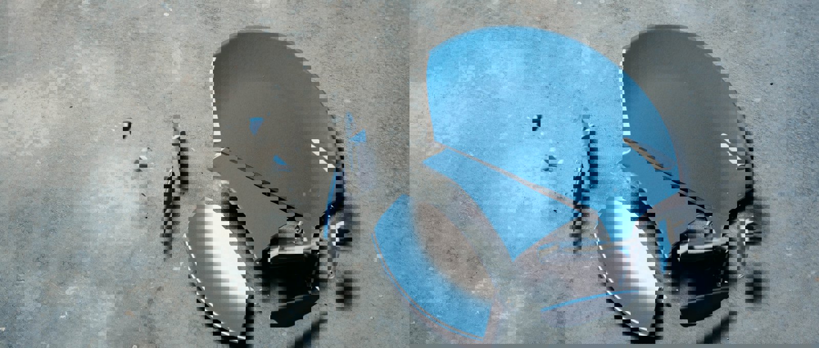 Blue ceramic plate broken on a grey concrete floor