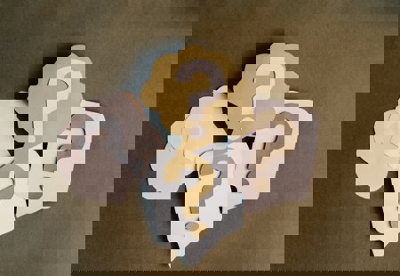 Photograph of four question marks made of paper cutouts