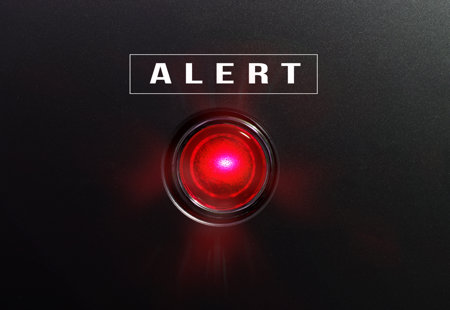Photograph of a sinister glowing red light with the word 'alert' written above it