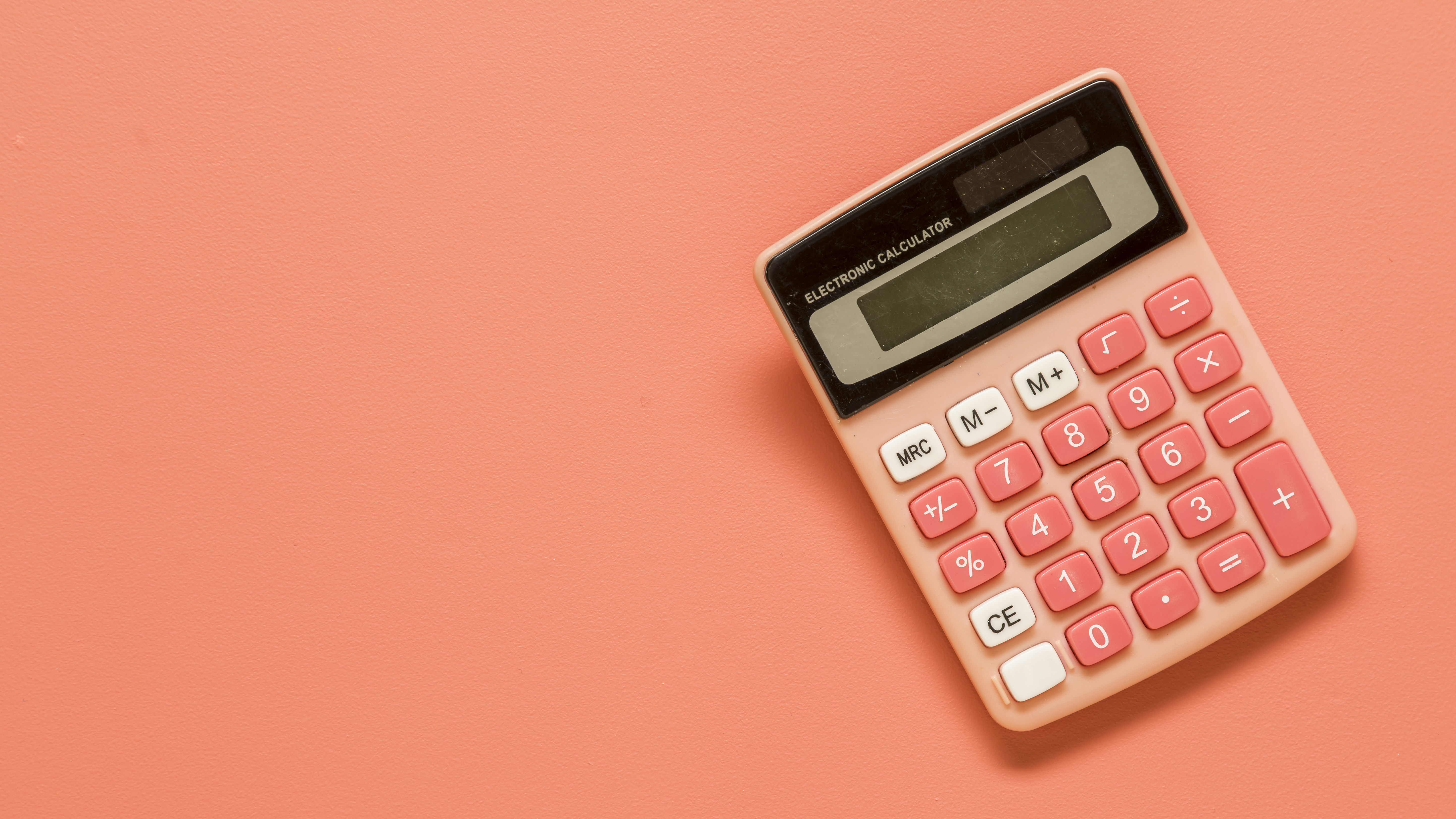 Photograph of a salmon-coloured calculator on a salmon-coloured background