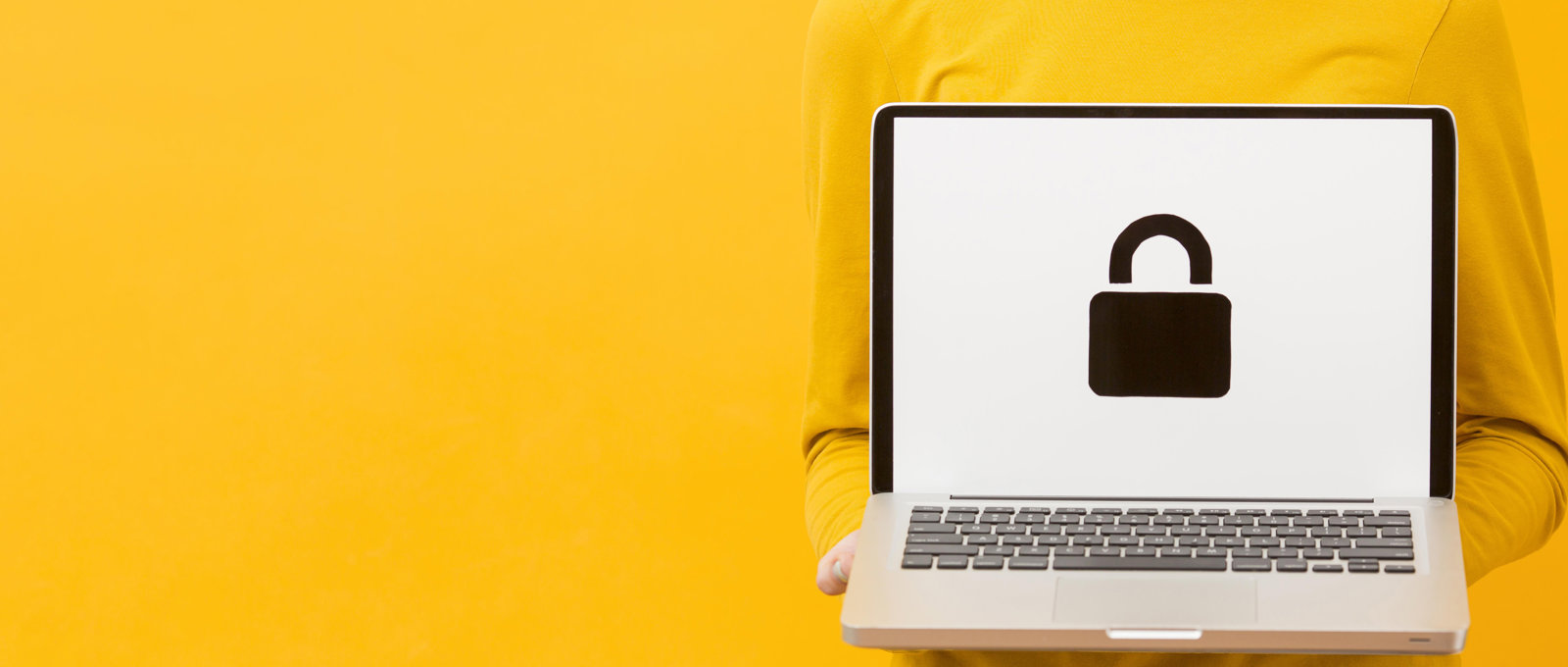 Photograph of a woman wearing yellow clothes against a yellow background. She is holding a laptop. On the screen is a padlock symbol.