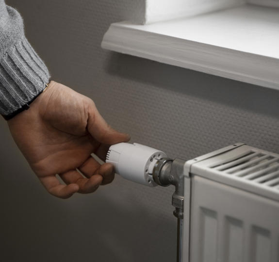 Man Turning Off Radiator During Energy Crisis