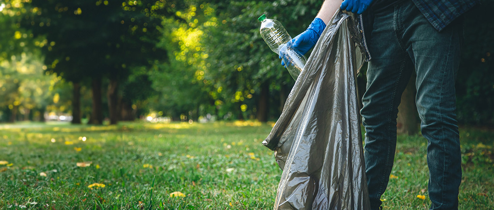 Man litter picking with a bin bag in a park