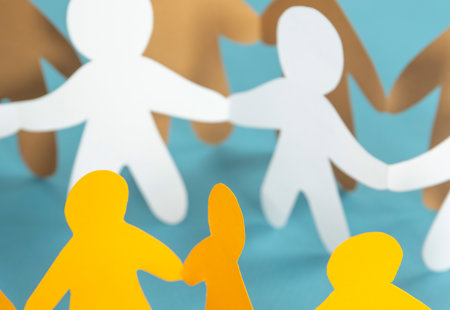 Simple white and yellow paperchain cut-outs of people holding hands arranged in alternating rows of yellow and white