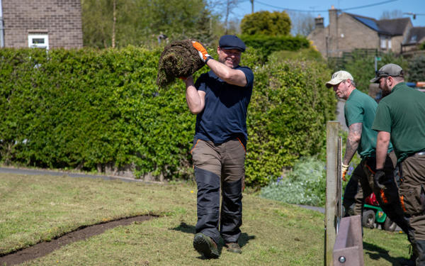 Man holding roll of grass