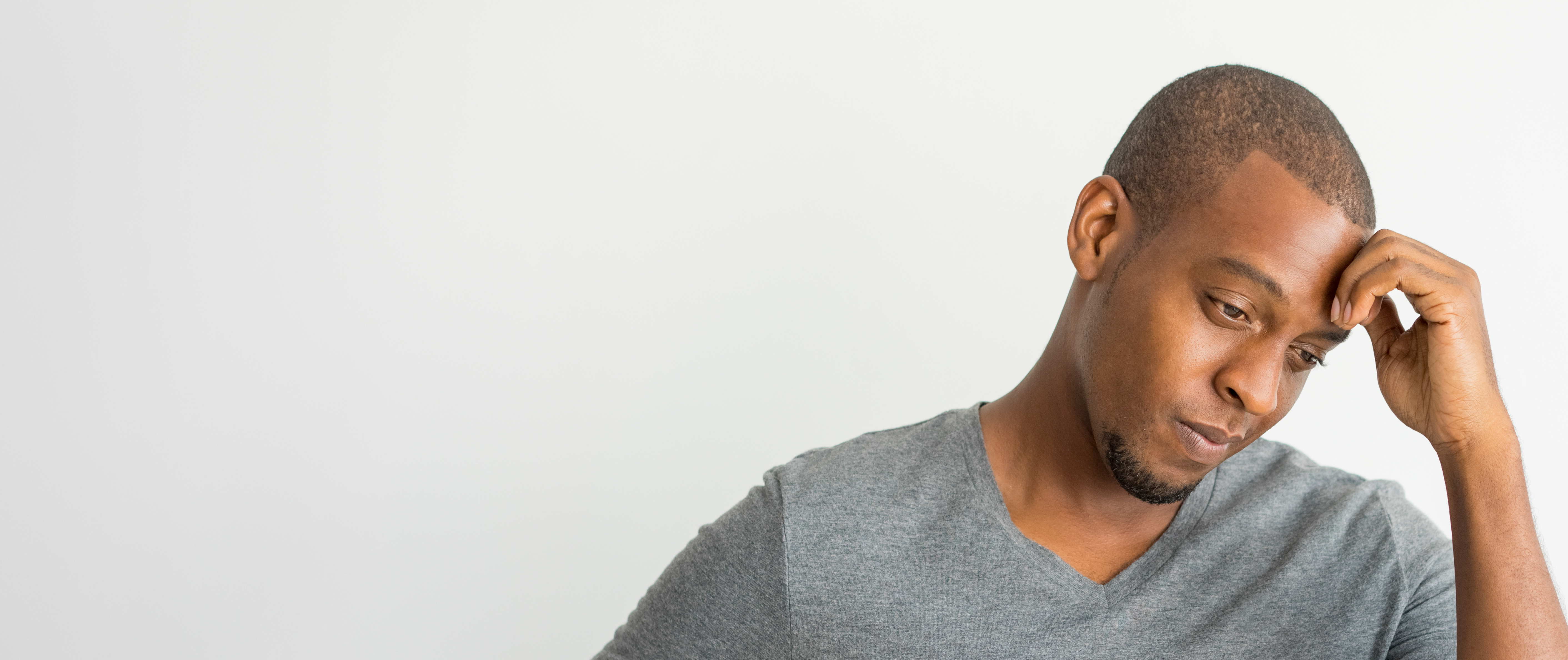 Photograph of a worried looking man with his hand to his forehead